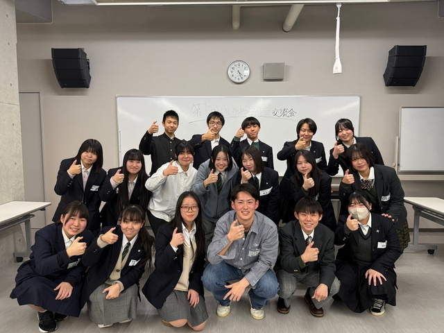 ホワイトボードの前で親指を立てる第2回交流会の参加者たち
